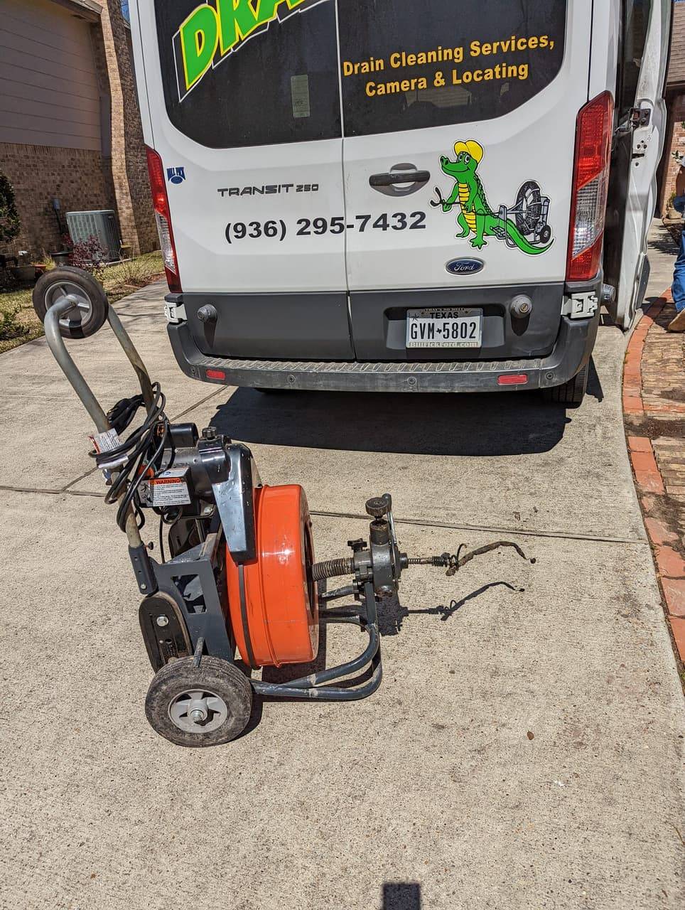 DrainCo service van and cable drain machine staged on a driveway