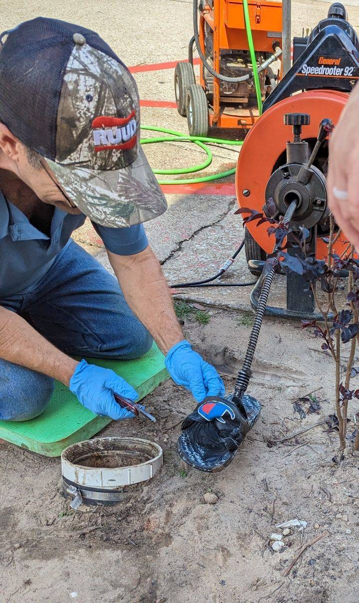 DrainCo technician working on a hydro-jetting machine and cleanout fitting